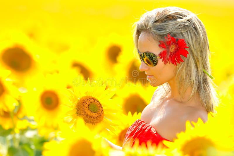 Beautiful young woman between sunflowers