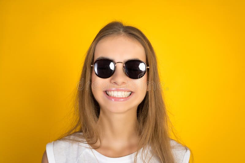 Beautiful Young Woman in Sunglasses Smiling Isolated on Yellow ...