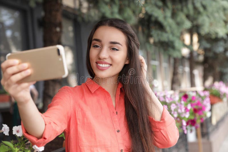 Beautiful young woman taking selfie outdoors on sunny royalty free stock image Beautiful young woman taking selfie outdoors on sunny royalty free stock image