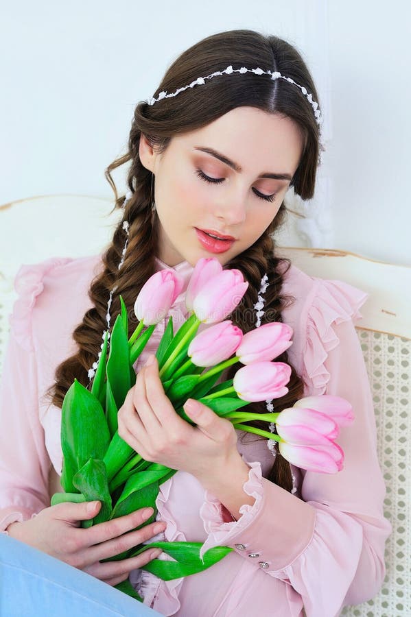 Beautiful young woman with tulips bouquet