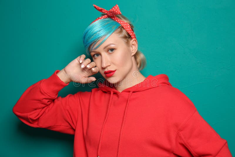 Beautiful young woman with unusual hair on color background