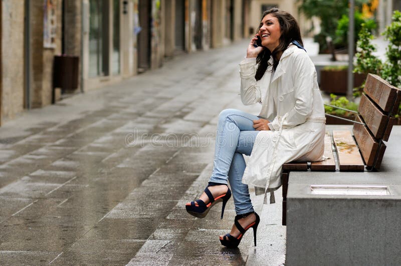 Beautiful young woman in urban background talking on phone