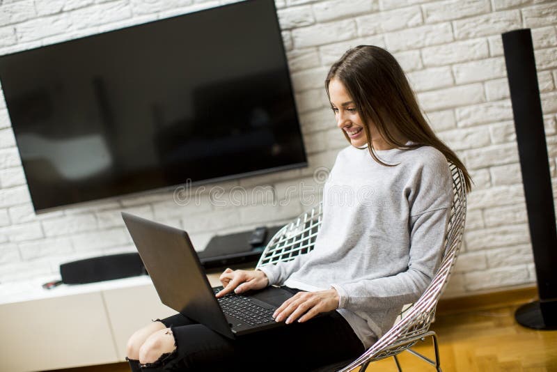 Beautiful young woman using laptop at home royalty free stock images Beautiful young woman using laptop at home royalty free stock images