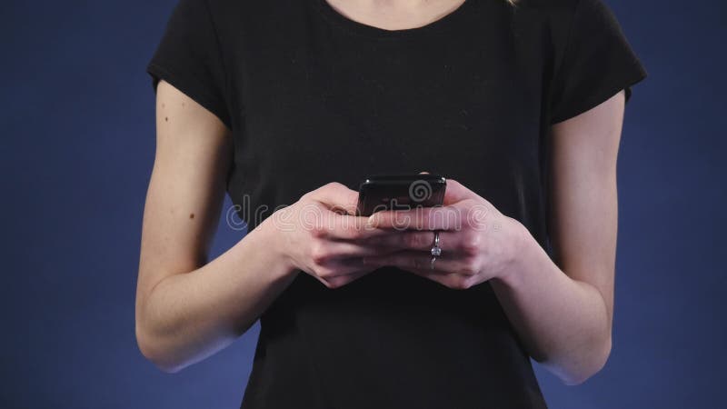 Beautiful young woman using smart phone with black background