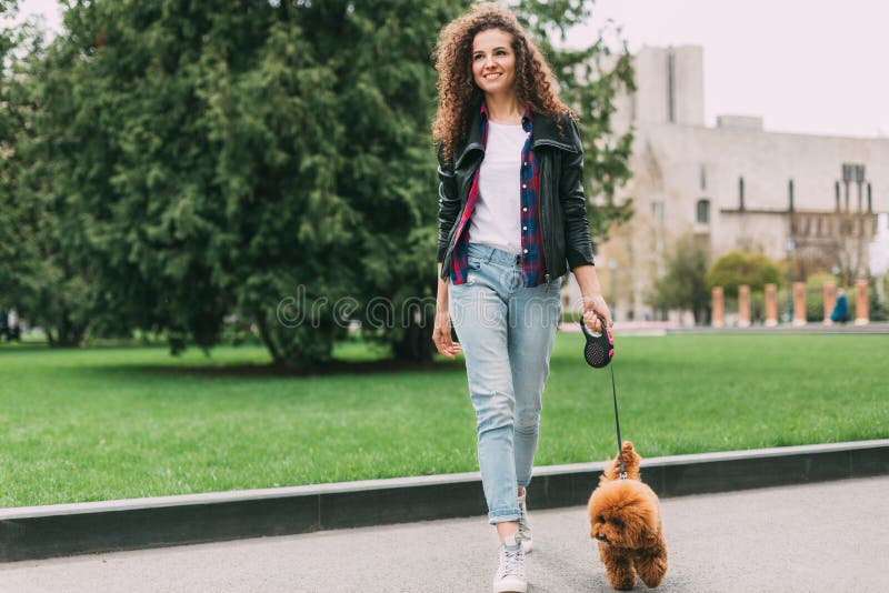 Beautiful young woman on a walk with cute poodle dog royalty free stock images Beautiful young woman on a walk with cute poodle dog royalty free stock images