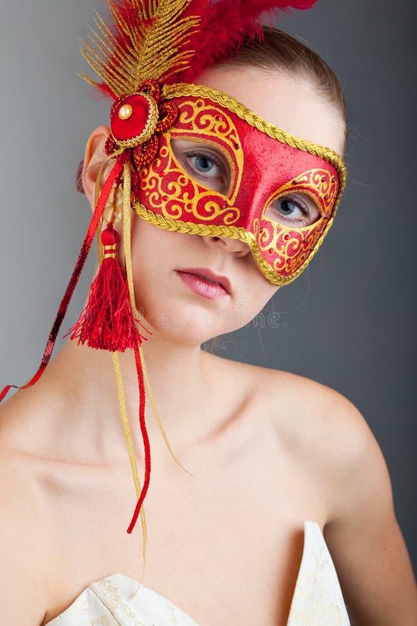 Beautiful young woman wearing red carnival mask