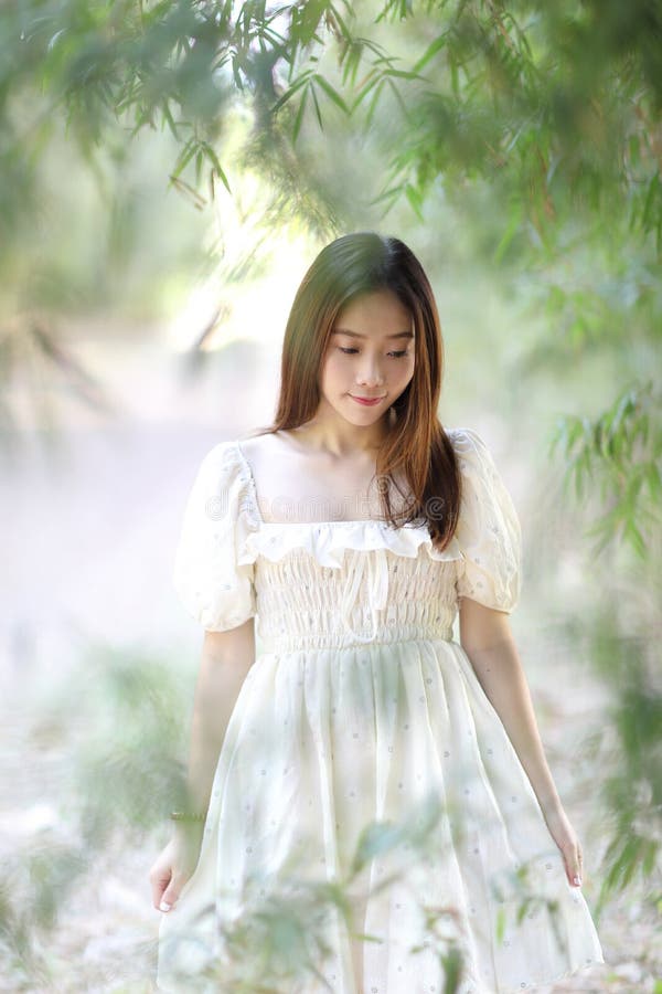 Beautiful young woman with white dress on garden background