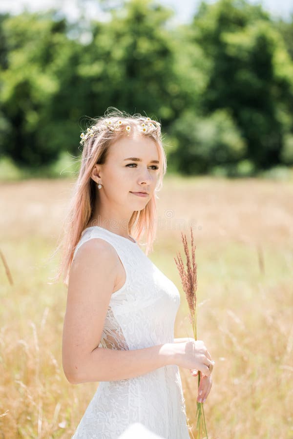 Portrait of a beautiful girl with pink hair decorated with little daisies