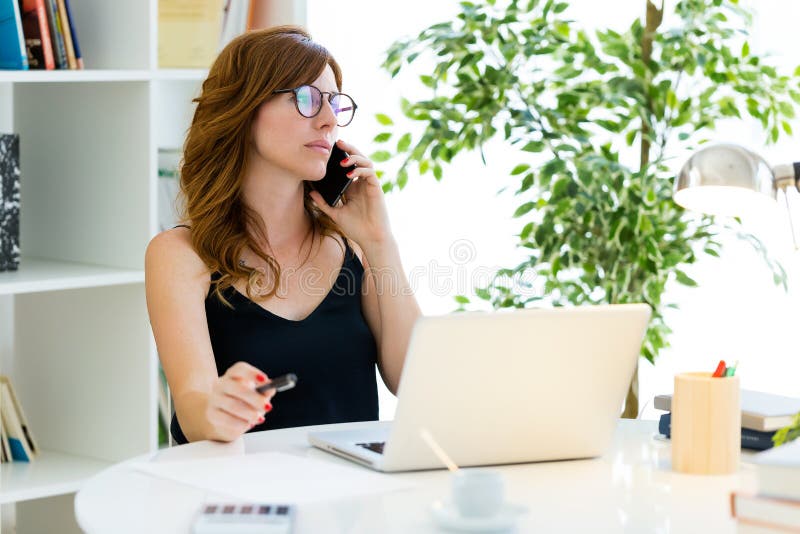 Beautiful young woman working with her mobile phone at home. stock photography Beautiful young woman working with her mobile phone at home. stock photography