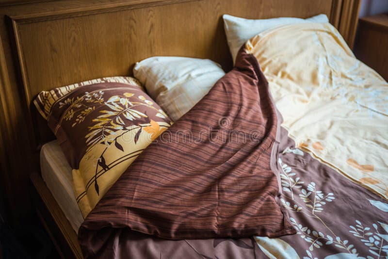 Beautifull Linens, Pillows and Blankets on Brown Wooden Bed and Stock