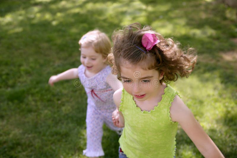 Beautifull little sisters running on the park stock images