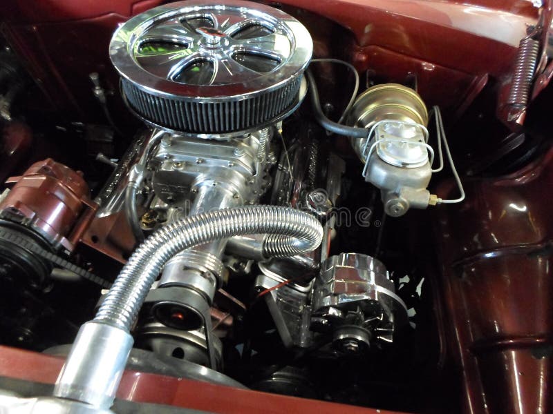 A beautifully restored classic car engine with chrome parts.