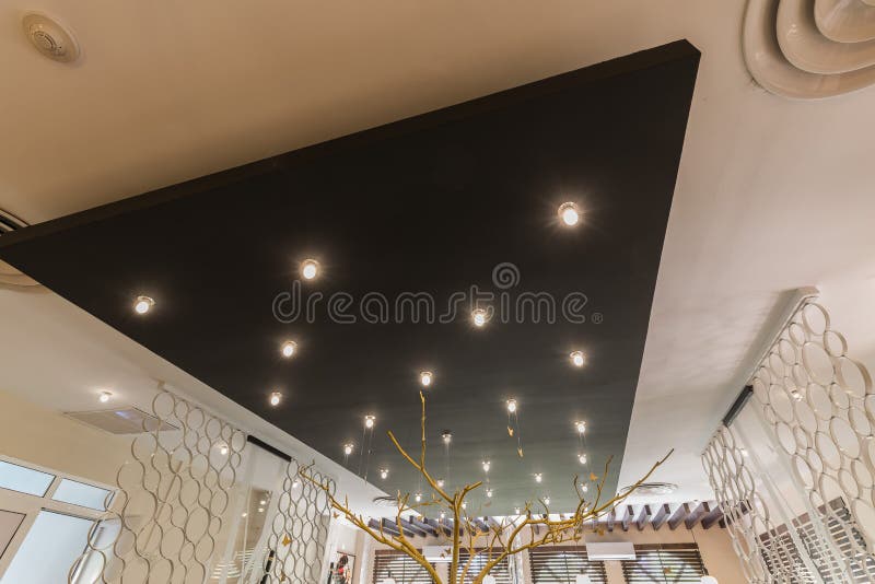 Beautifuul closeup view of interior stylish modern electrical ceiling lights on black panel stock images