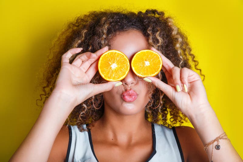 Beauty afro american Model Girl takes Juicy Oranges