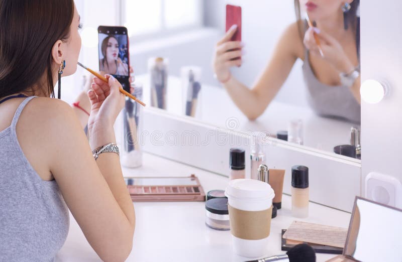 Beauty Blogger Filming Makeup Tutorial with Smartphone in Front of