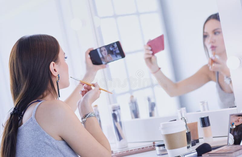Beauty Blogger Filming Makeup Tutorial with Smartphone in Front of
