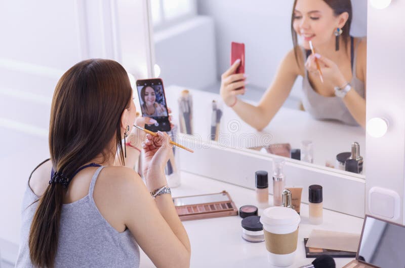 Beauty Blogger Filming Makeup Tutorial with Smartphone in Front of
