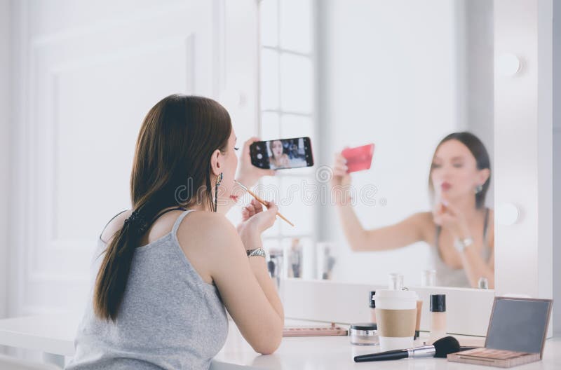 Beauty Blogger Filming Makeup Tutorial with Smartphone in Front of