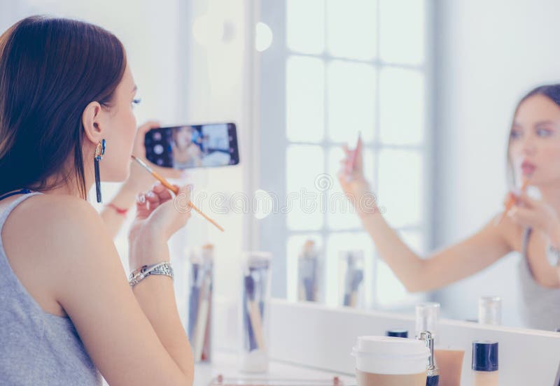 Beauty Blogger Filming Makeup Tutorial with Smartphone in Front of