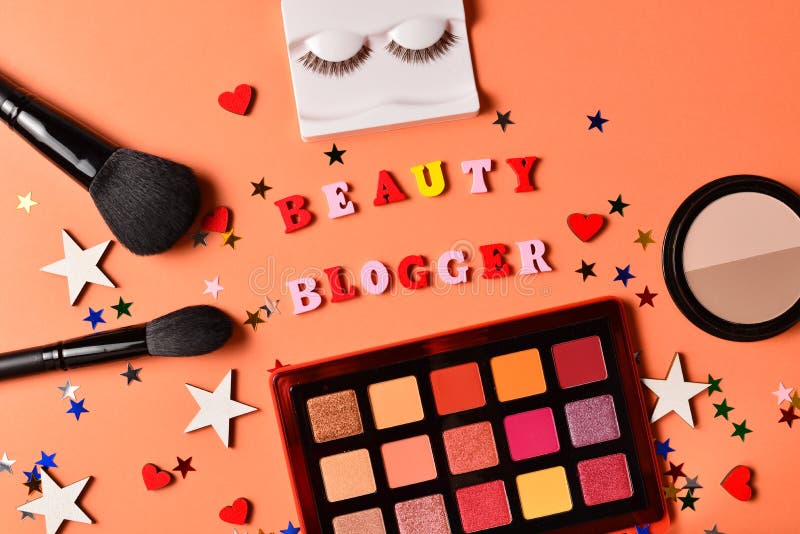 Beauty blogger text on an orange background. Professional trendy makeup products with cosmetic beauty products, eye shadows, eye stock images Beauty blogger text on an orange background. Professional trendy makeup products with cosmetic beauty products, eye shadows, eye stock images