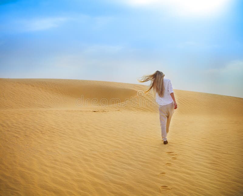 Beauty blond woman walking in Sahara desert. Tunisia.