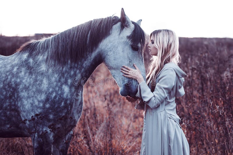 Beauty blondie with horse in the field