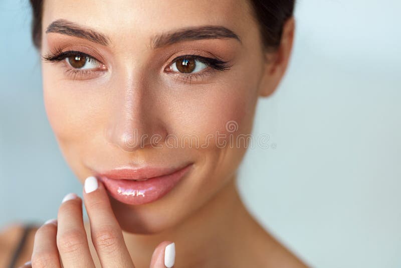 Beauty Face. Beautiful Woman Touching Lips With Lip Balm On