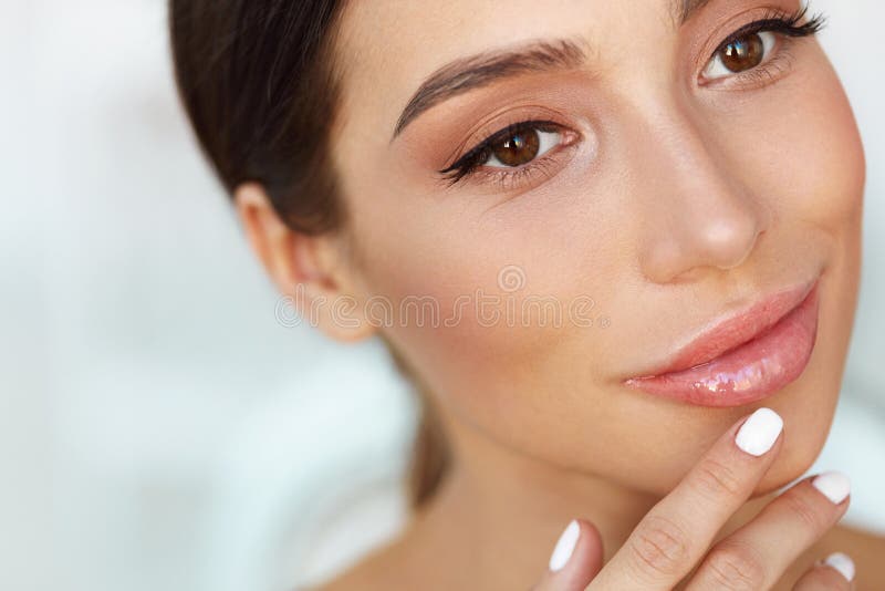 Beauty Face. Beautiful Woman Touching Lips With Lip Balm On