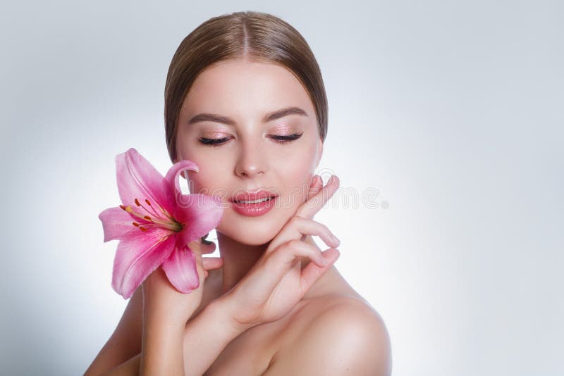 Beauty face of young woman with flower. Beauty treatment concept. Cosmetic concept royalty free stock image Beauty face of young woman with flower. Beauty treatment concept. Cosmetic concept royalty free stock image