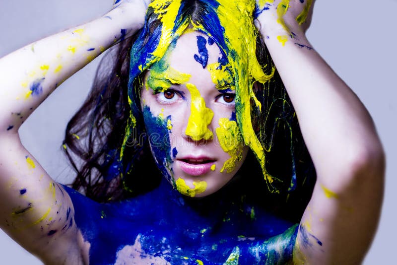 Beauty/fashion close up portrait of woman painted blue and yellow on white background