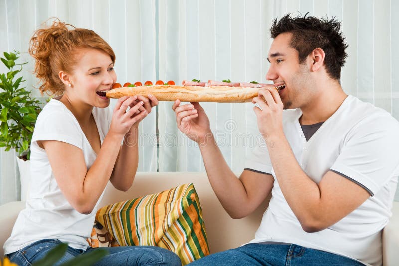 Beauty girl and a handsome boy eating sandwich