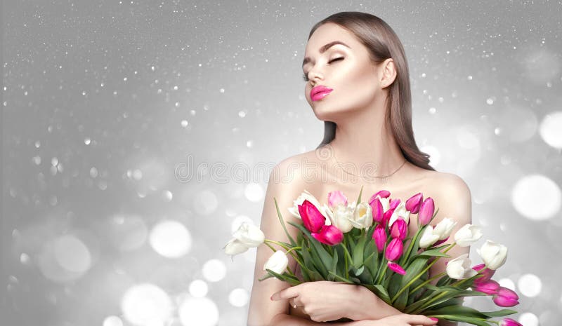 Beauty girl holding spring tulips. Beautiful woman receiving a bouquet of colorful tulips royalty free stock photos Beauty girl holding spring tulips. Beautiful woman receiving a bouquet of colorful tulips royalty free stock photos