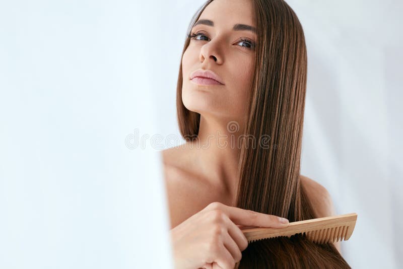 Beauty Hair Care. Beautiful Woman Combing Long Natural Hair royalty free stock images
