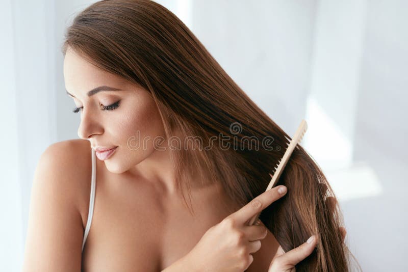 Beauty Hair Care. Beautiful Woman Combing Long Natural Hair royalty free stock image