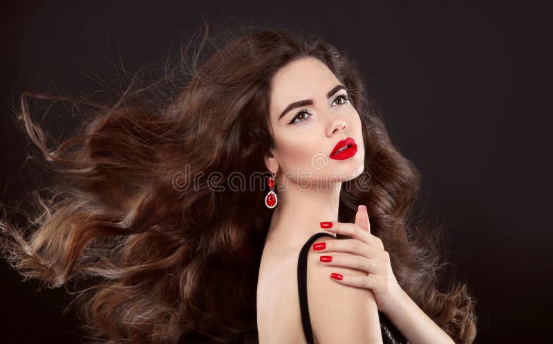 Beauty hair. Red manicure. Brunette girl with makeup and long sh