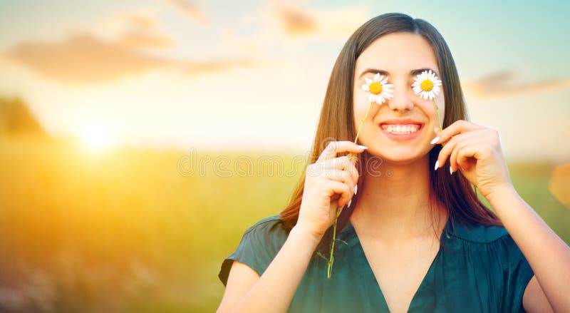 Beauty joyful girl with daisy flowers on her eyes enjoying nature and laughing on summer field royalty free stock image Beauty joyful girl with daisy flowers on her eyes enjoying nature and laughing on summer field royalty free stock image
