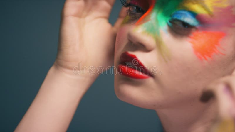 Woman, beauty and portrait with rainbow hand paint art on face in studio  with glow. Creative skin a Stock Photo by YuriArcursPeopleimages