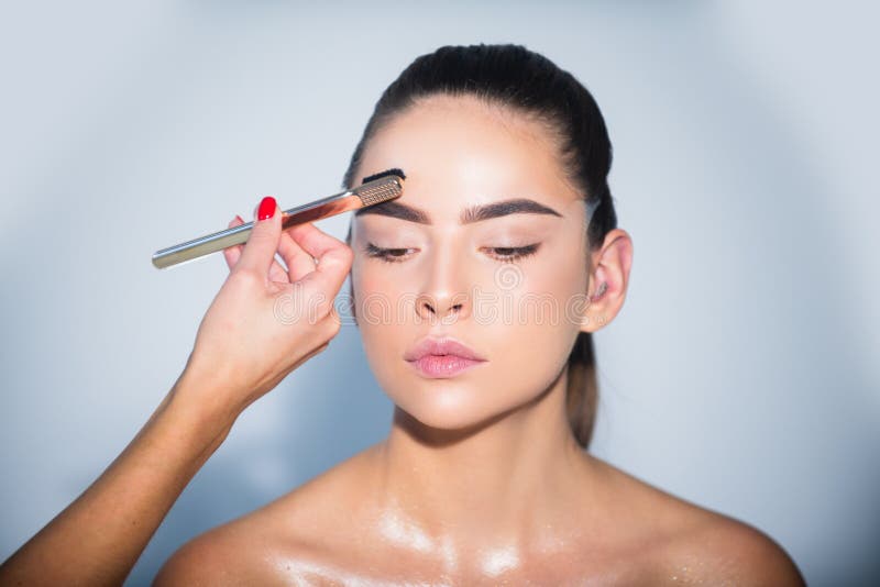 Beauty makeup. Girl with beautiful bright make up. Woman applying black mascara on eyelashes with makeup brush. Brows