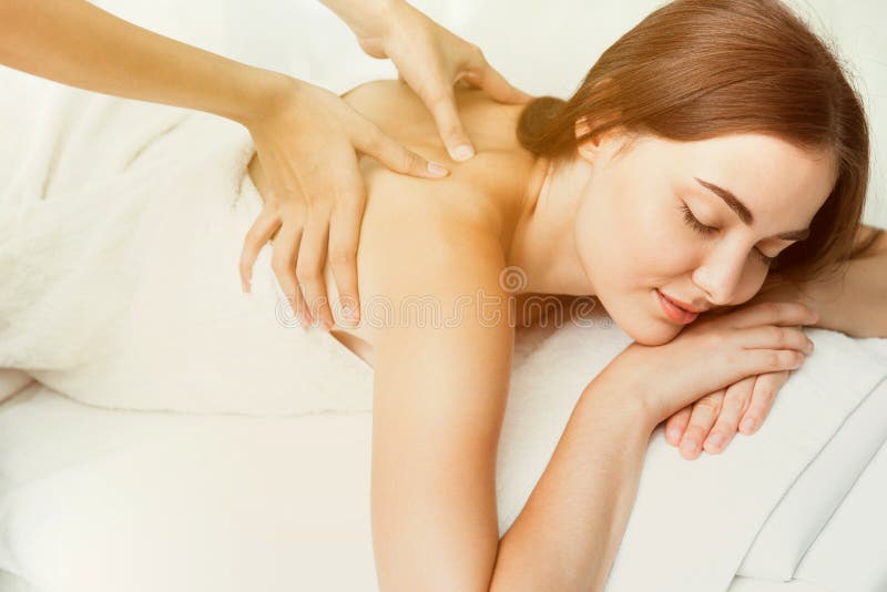 Beauty model with back neck pain massage at spa warm tone