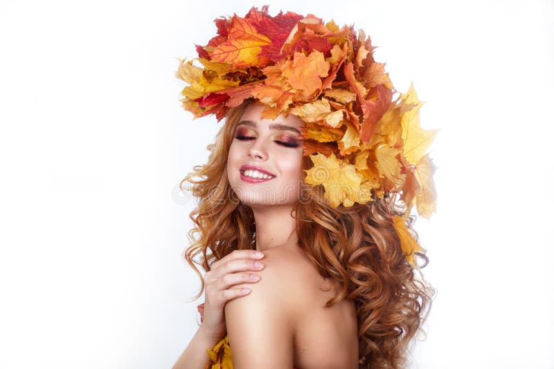Beauty model girl with autumn bright leaves hairstyle. Beautiful Fashion female with Autumnal Make up and Hair style. Autumn woman