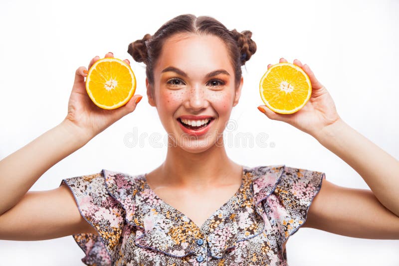 Beauty Model Girl with Juicy Oranges. Beautiful Joyful teen girl with freckles, funny red hairstyle and yellow makeup