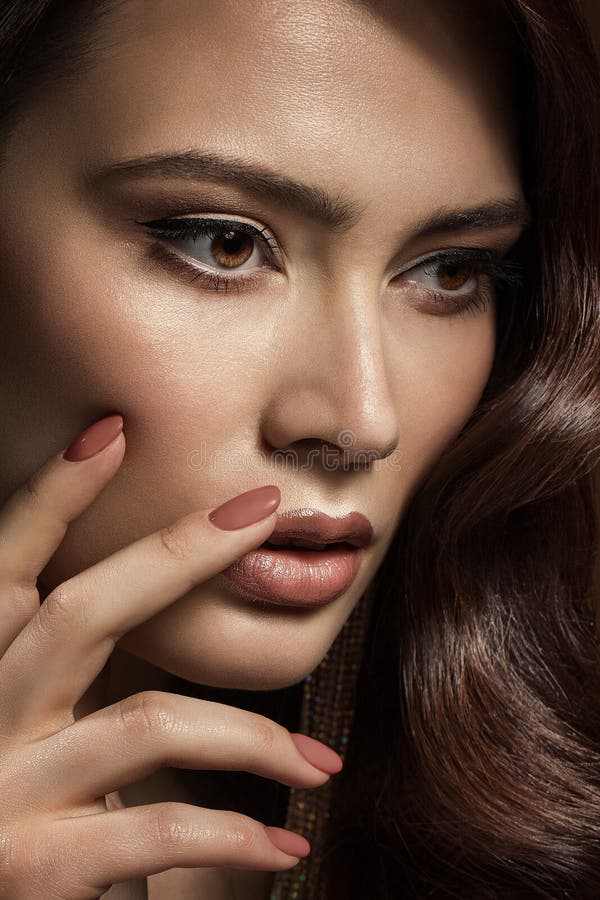 Beauty Model with Nails Manicure and Beige Lipstick Makeup. Beautiful Girl showing Nail Polish Cosmetic. Woman Make up Face. Profile View Closeup