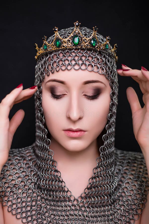 Beauty portrait of a woman in a chainmail hood with a crown on her head. Model with clear skin  retouching.