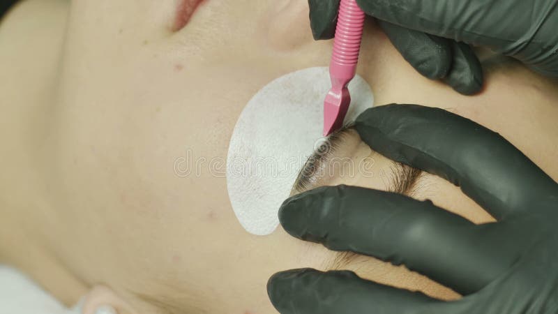 Beauty salon, eyelash extensions. Female eyes close up with selekonovoy overlay eyelid. the master of the salon presses stock video footage Beauty salon, eyelash extensions. Female eyes close up with selekonovoy overlay eyelid. the master of the salon presses stock video footage