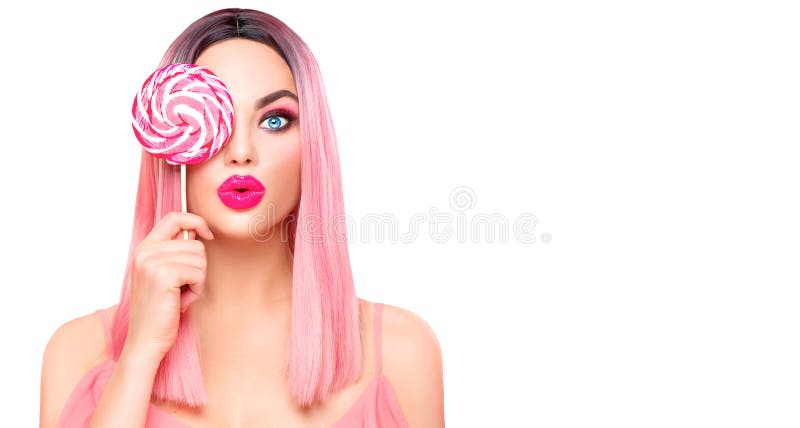 Beauty model woman with trendy pink hairstyle and beautiful makeup holding lollipop candy isolated on white