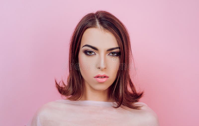 Beauty woman face on pink background. Hairstyle styling. Fashion, beauty, cosmetics. Perfect makeup, smooth skin royalty free stock photo Beauty woman face on pink background. Hairstyle styling. Fashion, beauty, cosmetics. Perfect makeup, smooth skin royalty free stock photo