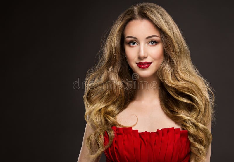 Beauty Woman with Long Wavy Hair. Dark Blonde Girl with Curly Shiny Hairstyle. Fashion Model Red Lips Make up Portrait over Black