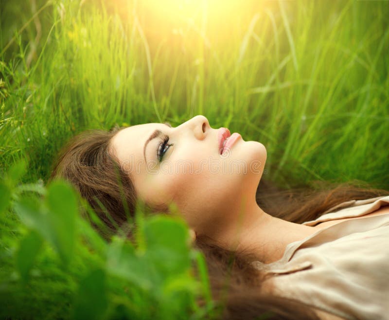 Beauty woman lying on the field and dreaming