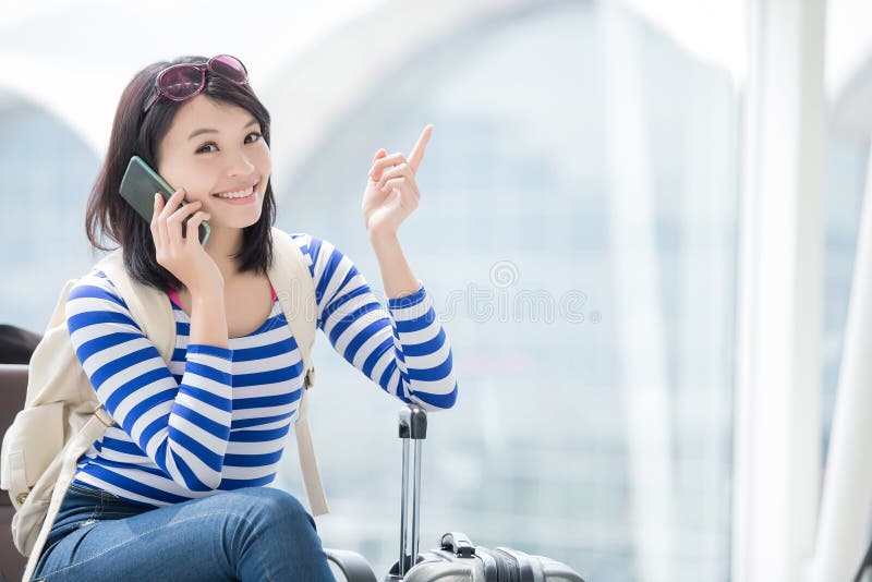 Beauty woman is talking the phone happily and show something in hong kong, asian. Beauty woman is talking the phone happily and show something in hong kong, asian