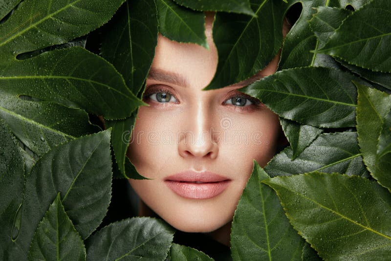 Beauté normale Beau visage de femme dans des feuilles vertes